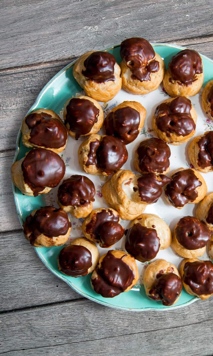 espresso custard filled cream puffs on a blue plate