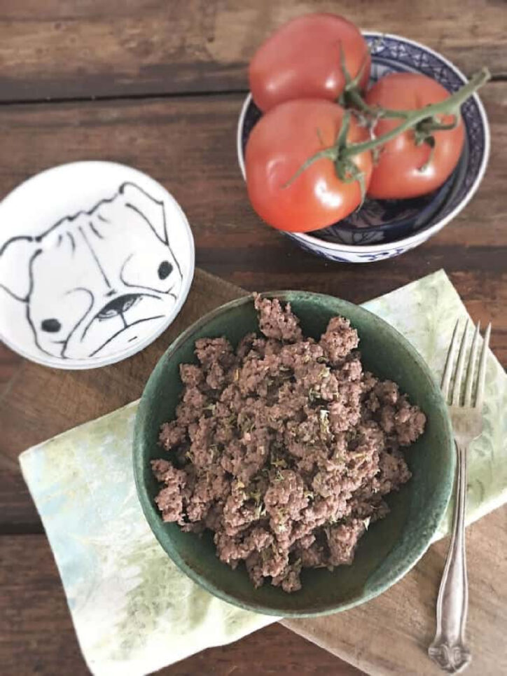 Bowl of ground beef on table. 