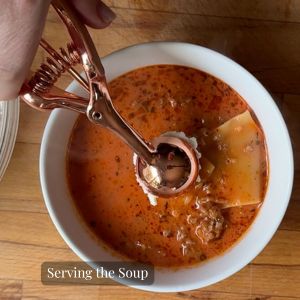 cheese topping being added to lasagna soup