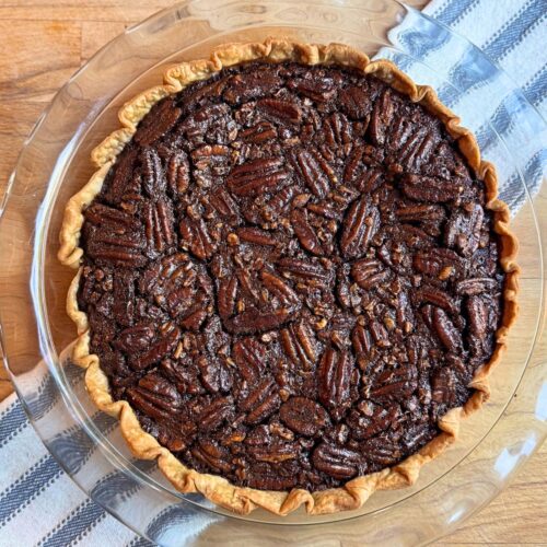 Old fashioned chocolate pecan pie on a blue and white towel