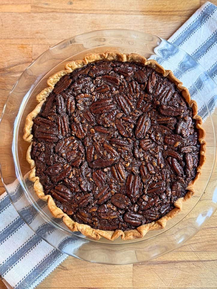 Old fashioned chocolate pecan pie on a blue and white towel