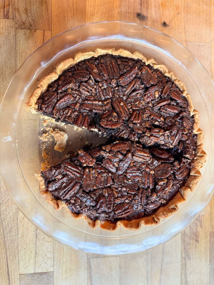 Old fashioned chocolate pecan pie with a slice missing