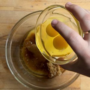 Adding eggs to pumpkin cranberry bread mix