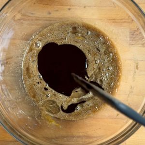 Adding chocolate and melted butter to  pecan pie mixture 