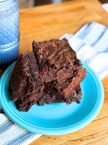 3 Ingredient brownies on a blue plate with a glass of milk