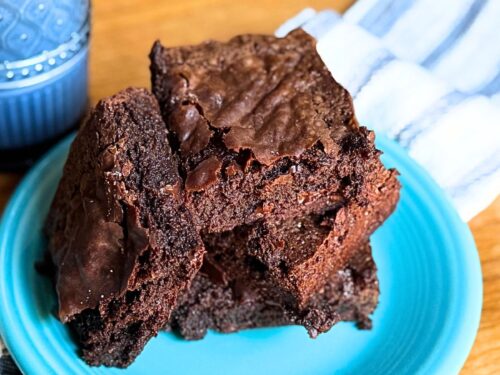 3 Ingredient brownies on a blue plate with a glass of milk