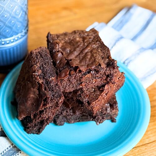 3 Ingredient brownies on a blue plate with a glass of milk