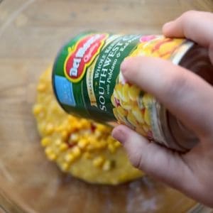 adding southwest style corn to a bowl