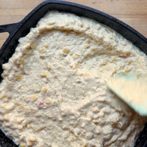 putting casserole in a cast iron skillet to bake