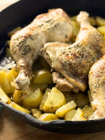 Whole chicken legs roasted over potatoes