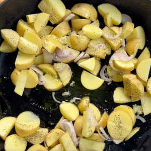 chopped yellow potatoes and shallots in a cast iron skillet