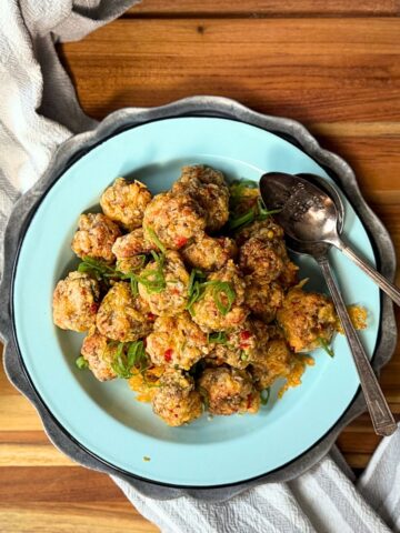 Pimento Cheese Sausage balls on a plate with a green onion garnish