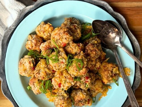 Pimento Cheese Sausage balls on a plate with a green onion garnish