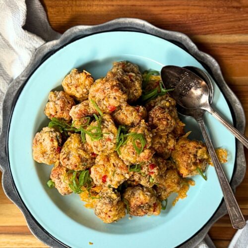 Pimento Cheese Sausage balls on a plate with a green onion garnish