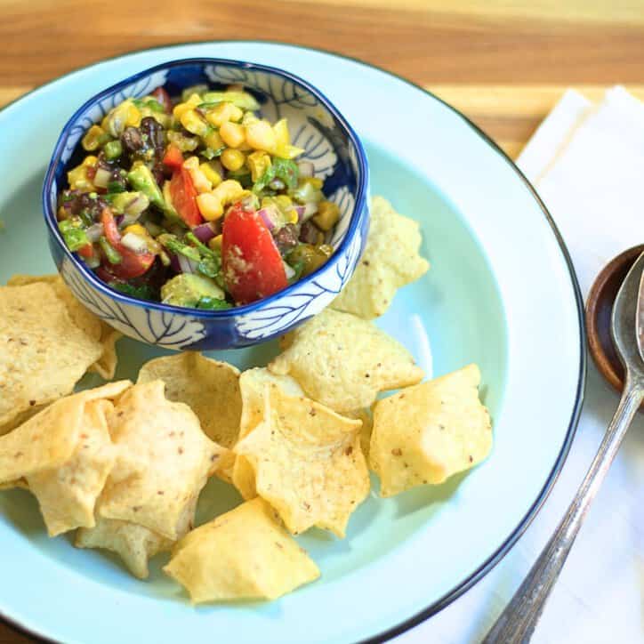 chopped vegetables with a dressing in a blue and white bowl